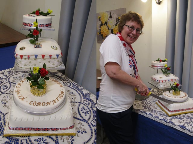 Reverend Rachel Hetherington makes the first cut to the delicious Coronation cake, which was made and decorated by independent living resident, Grace.