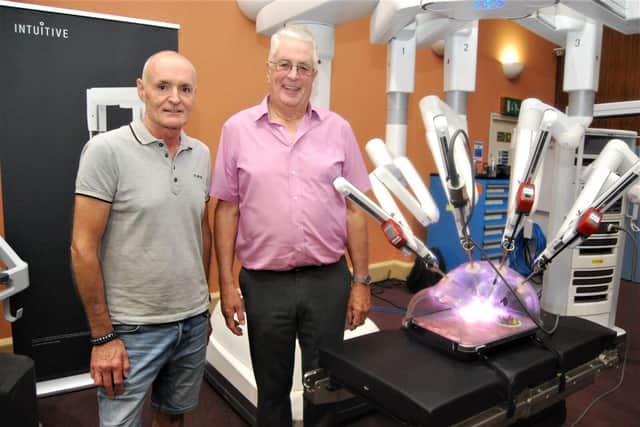 Patients Ian Dowell and Ross Thompson with the robot.