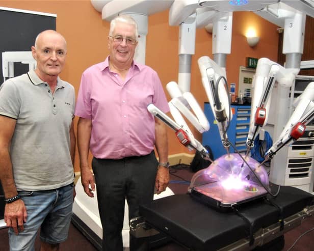 Patients Ian Dowell and Ross Thompson with the robot.