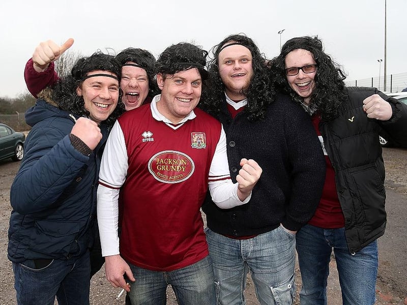 Northampton Town fans wear long hair wigs and headbands in homage to John-Joe O'Toole prior to the Sky Bet League Two match between Mansfield Town and Northampton Town at One Call Stadium on February 14, 2015.