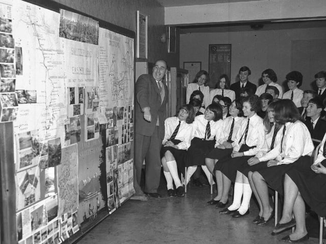 School pupils with map and pictures of Switzerland. Sign on map says Switzerland Easter 1966 and Bernese Oberland