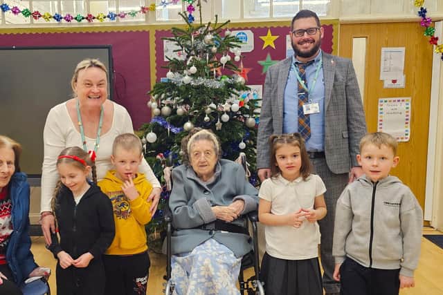 Head Teacher Liam Cox and Teaching Assistant Mrs Attwood with the pupils of Park Road Infant School and the residents of Elm Bank Care Home