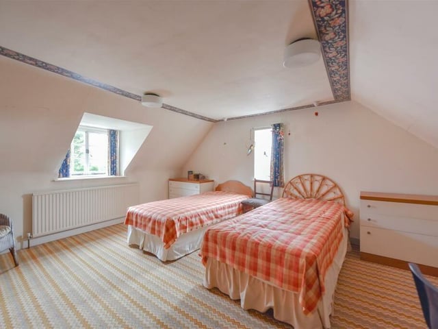 A loft bedroom is bouncing with light from windows on two sides