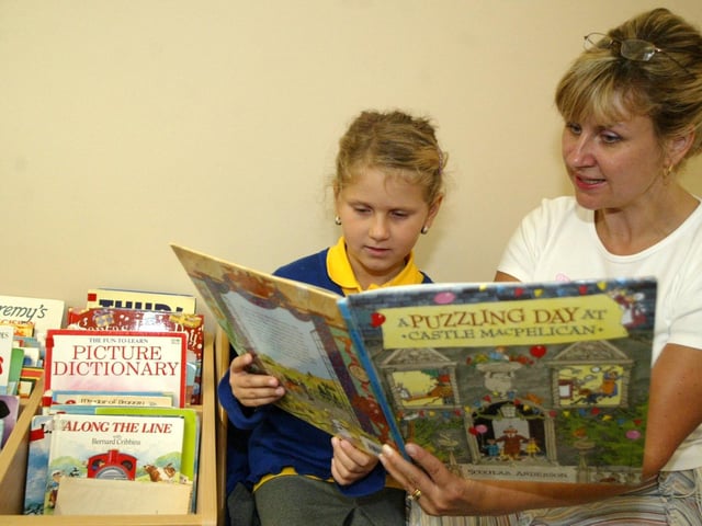 Weston Favell CEVA Primary School. Pictured: Sarra, 7, reading in the library with Jo MacKenzie.