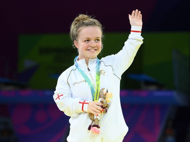Maisie Summers-Newton waves to the crowd at the medal ceremony at the Commonwealth Games