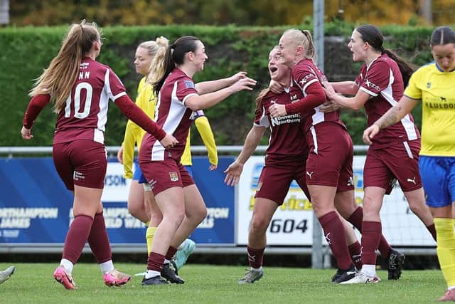 Cody Webb is congratulated by team-mates Alyx Mills, Bianca Luttman and Paige Ridley after against AFC Sudbury at O'Riordan Bond Stadium on October 26, 2025 in Northampton, England. (Photo by Pete Norton/Getty Images)