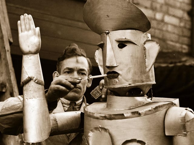 15th January 1939:  Mr Charles Lawson, an electrical engineer of Kettering lights his robot's cigarette.  (Photo by Fox Photos/Getty Images)
