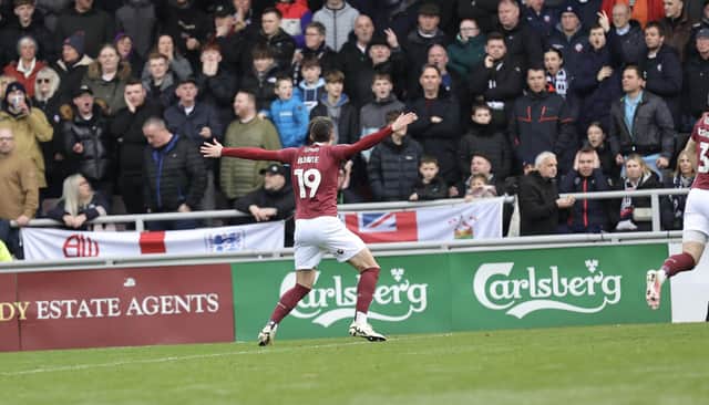 Kieron Bowie celebrates in front of the Bolton fans after giving Cobblers a very early lead at Sixfields.