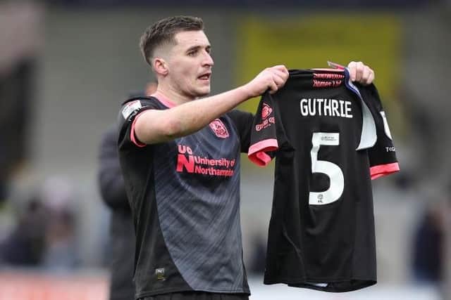 Aaron McGowan holds up Jon Guthrie's shirt in front of the away fans at Burton