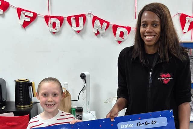 Lorraine Lewis receives the cheque from Woo.