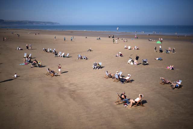 People enjoy the sunshine and high temperatures on Whitby beach (Photo by Christopher Furlong/Getty Images)