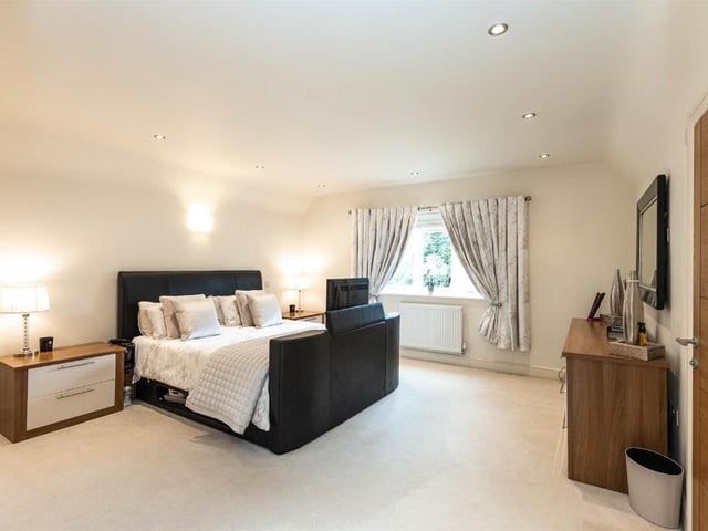 This modern family home is in a picturesque village and shares its boundary with a church.