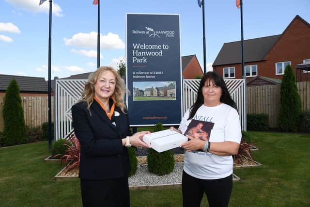 Sandra, Sales Advisor at Hanwood Park, hands over an iPad to Teresa Jackson - mother of Niall Healey