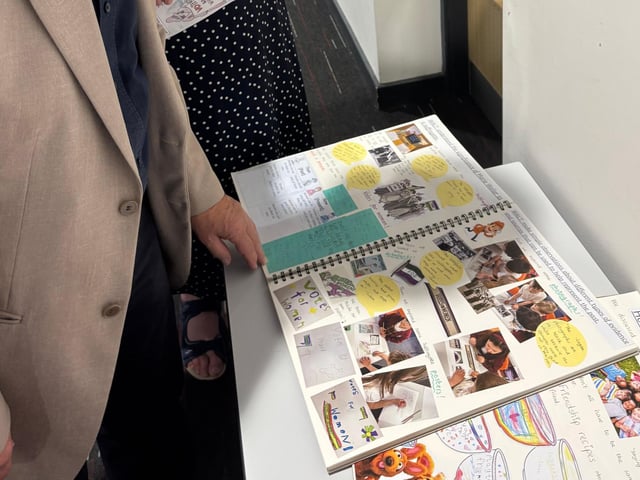 Marie's family viewing the Y1 History Floorbook of Significant People