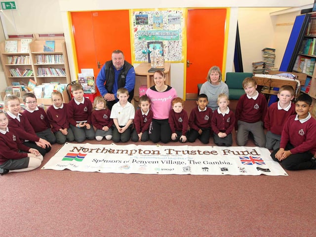 Pupils from Queen Eleanor Primary School bringing in bronze coins to help with a fund-raiser by PE teacher Gemma Jackson, who is sponsoring a child in Gambia.
Andy Butler, Northampton Trustee Fund founder, teacher Gemma Jackson and Anne Butler, Northampton Trustee Fund founder, with pupuils who have spelt out 'Northampton Trustee Fund' with bronze coins.
