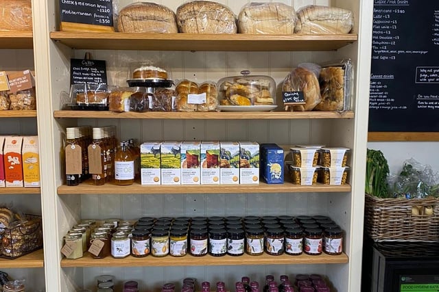 Local produce, bread, cakes, and cupboard essentials are pictured inside the shop.