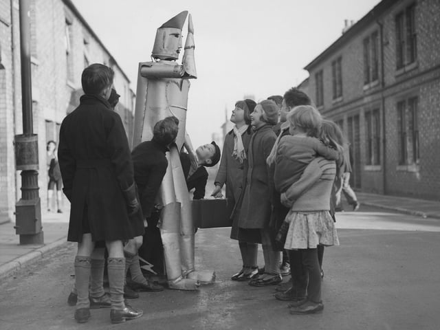 15th January 1939:  The children of Kettering in Northamptonshire stare in amazement at a walking talking robot, the invention of local electrical engineer Charles Lawson.  (Photo by Harry Todd/Fox Photos/Getty Images)