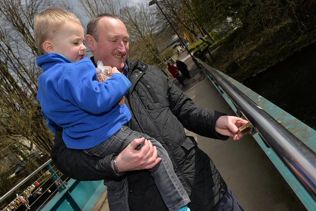 Padlock bridge in Bakewell town centre, pictured are Frank Combes with Freddie Benson reading the messages on the padlocks in 2015