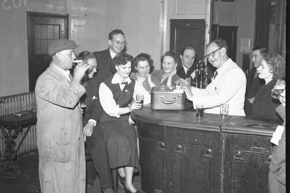 Man at bar with reel to reel tape recorder