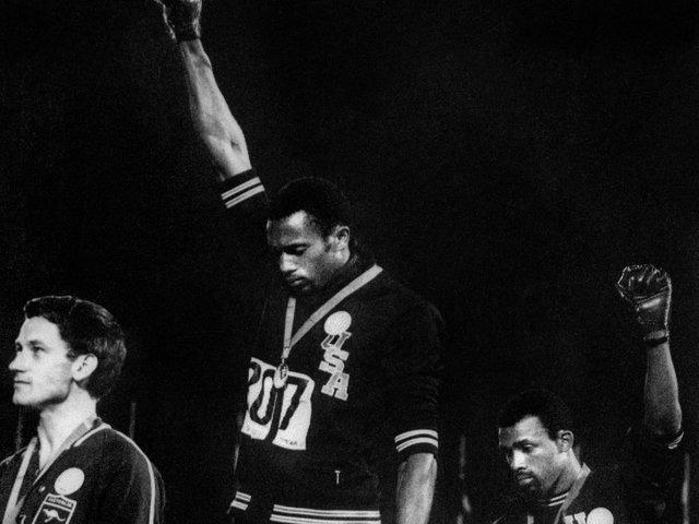 During their medal ceremony, African-American athletes Tommie Smith and John Carlos each raised a black-gloved fist during the playing of the US national anthem to protest. They then turned to face the US flag and kept their hands raised until the anthem had finished.