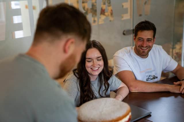 A team smiling as they anticipate enjoying an entry for the Best Office Baker.