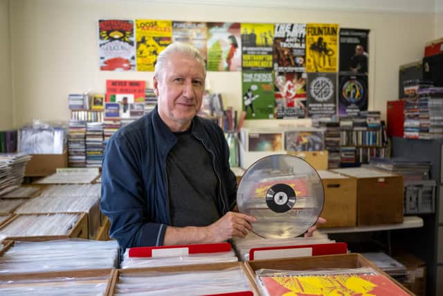 Alex Novak at Spiral Archive in Northampton, pictured with a silver 12" record to celebrate the 25th anniversary of the music shop.