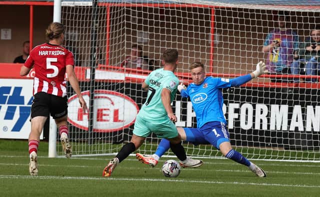 Sam Hoskins slots in the opening goal against Exeter on Saturday.