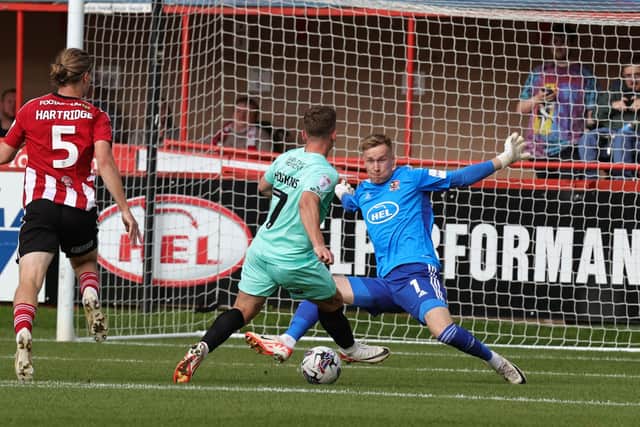 Sam Hoskins slots in the opening goal against Exeter on Saturday.