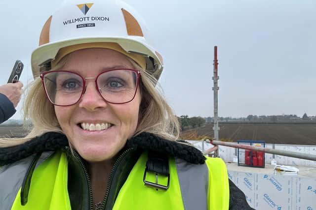 Emma Butler on the roof of Tiffield Academy in hard hat and high vis