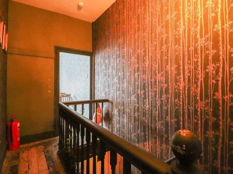 The first floor hallway leads to each of the five bedrooms of the townhouse