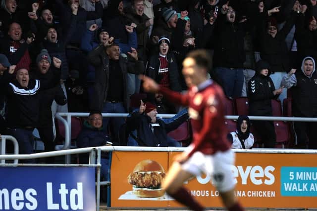 Cobblers fans celebrate after Kieron Bowie scores against Cambridge United.