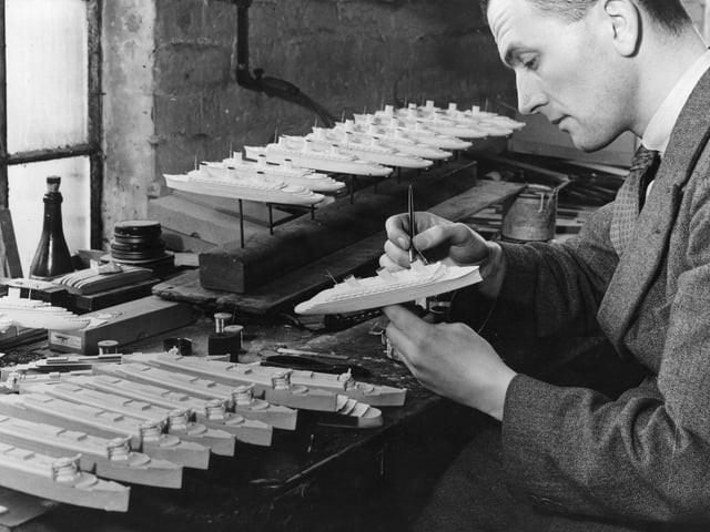 4th June 1935: A craftsman in Northampton at work on souvenir models of the French liner 'Normandie' which has just completed its maiden Atlantic crossing. (Photo by Fox Photos/Getty Images)