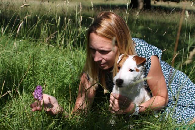 Courteenhall Events Manager Natalie Baxter with dog Wilf and a Pyramidal Orchid