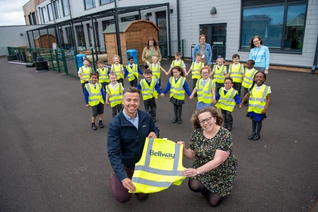 •	Bellway Sales Manager Andrew Odams, with Head of School Sarah Whitlock and youngsters posing with their hi-vis jackets