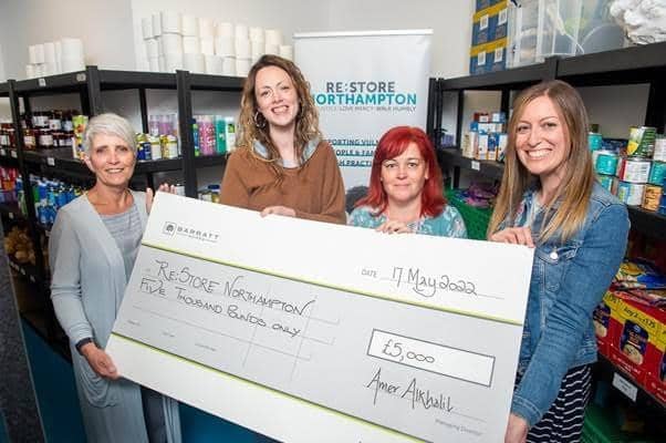 Jacqui Patrick (left) handing the cheque to the team at Re:Store Northampton.