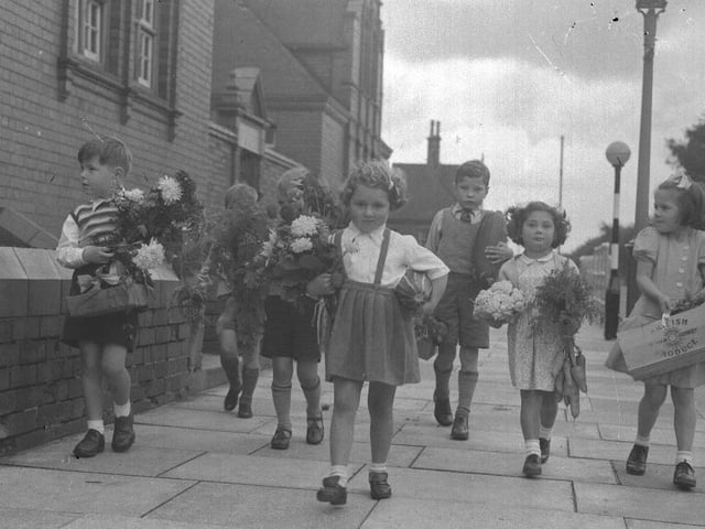 Small children with bunches of flowers