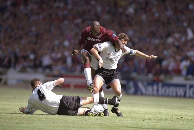 John Gayle attempts to dribble through two Swansea City defenders during Northampton Town's play-off final win.
