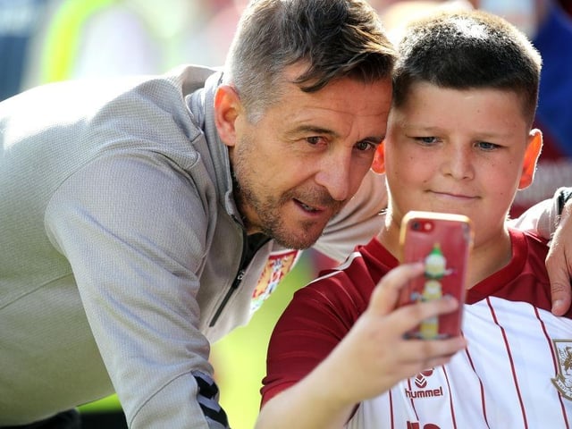Northampton Town manager Jon Brady has a selfie taken by a young fan at the end of the Sky Bet League Two between Crewe Alexandra and Northampton Town on August 20, 2022.