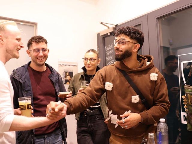 Xen greeting individuals coming to watch the documentary.
