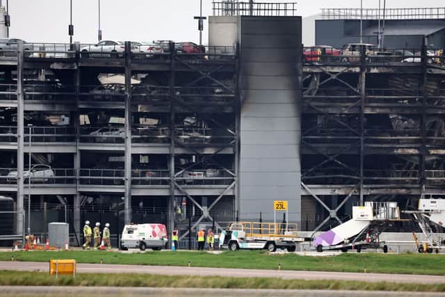Burned out cars are pictured in a charred section of car park. Photo by HENRY NICHOLLS/AFP via Getty Images