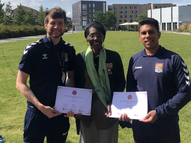 Morcea Walker MBE VLL presenting Damon Fox & Akshay Mistry from Northampton Town FC Community Trust with their Rose of Northamptonshire Awards. Damon Fox and Akshay Mistry work for Northampton Town FC Community Trust, running a variety of programmes to support local residents with their physical and mental wellbeing