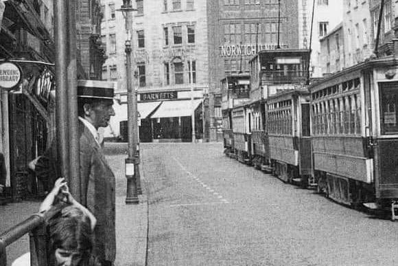 Well-dressed man waiting for a tram car in Drapery. Pre 1930s.