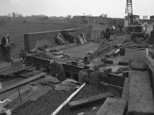 Workmen building bridge, location unknown