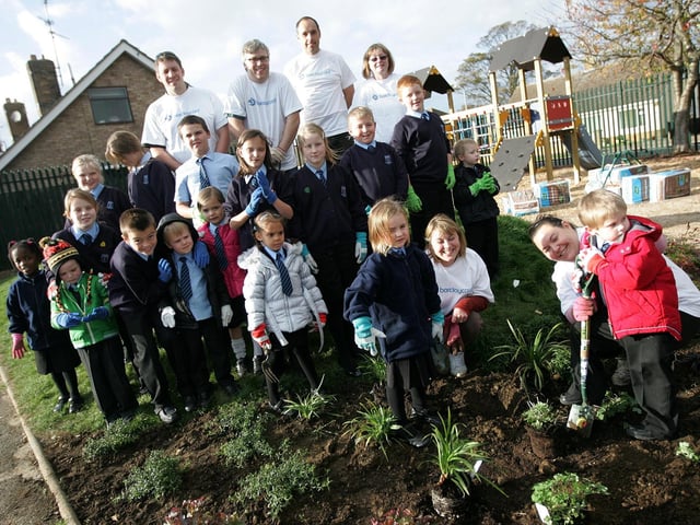 Barclaycard volunteers helping pupils to plant flowers at Hardingstone Primary School.