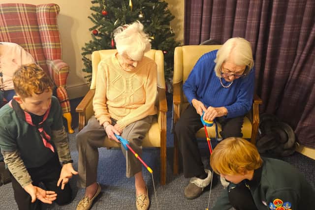 Young cubs showing the residents at Elm Bank how to play the fishing game