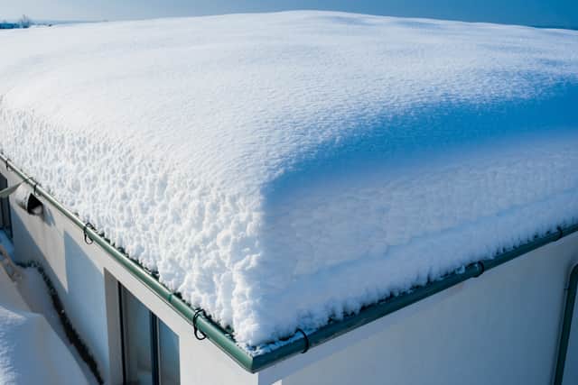 Heavy snow on a flat roof can cause structural damage.