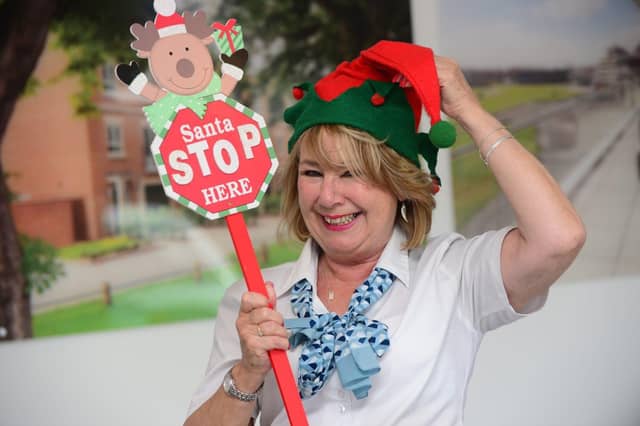 A Barratt and David Wilson Homes Sales Adviser with a Santa Stop Here sign