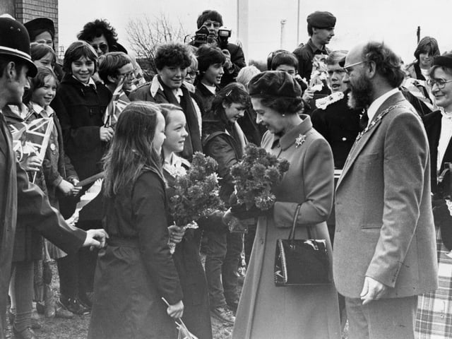 Twins Lynn and Donna Pitt hand over posies outside Queen Elizabeth School in 1982