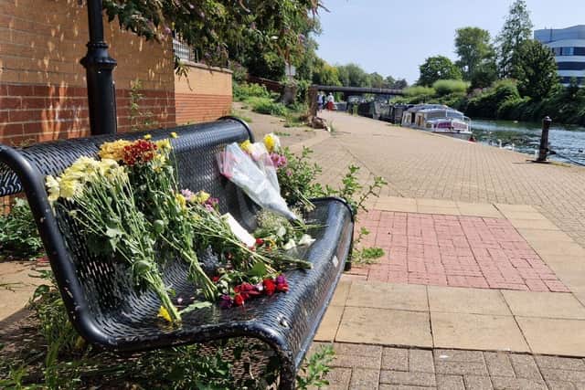 Flowers left at the scene on a bench by the River Nene behind Auctioneers Court. Photo: Logan MacLeod.
