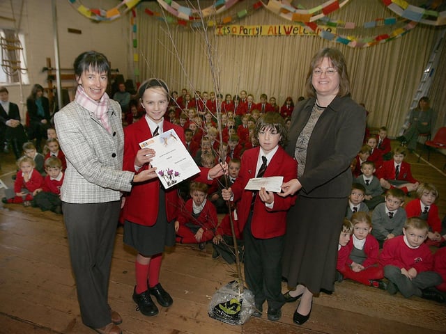 Quinton House Junior School from left Linda Marshall of the Wildlife Trust pupils Alice Frost and Louie Draper with teacher Susan Haynes - the school has raised money for the wildlife trust and in return are presented with a tree.